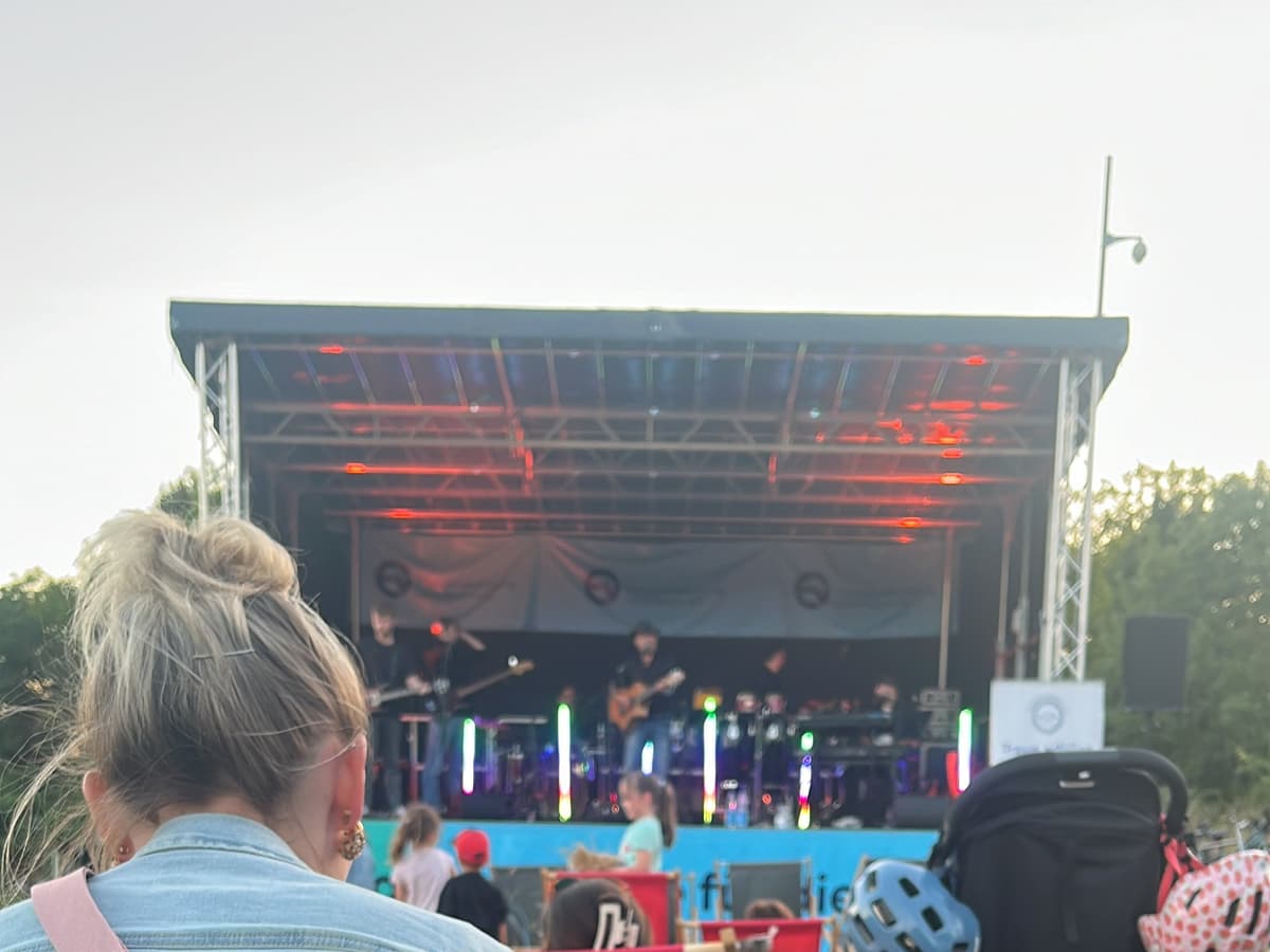 Open-Air-Bühne mit Band und Publikum, im Vordergrund das Tablet zur Mischpultsteuerung
