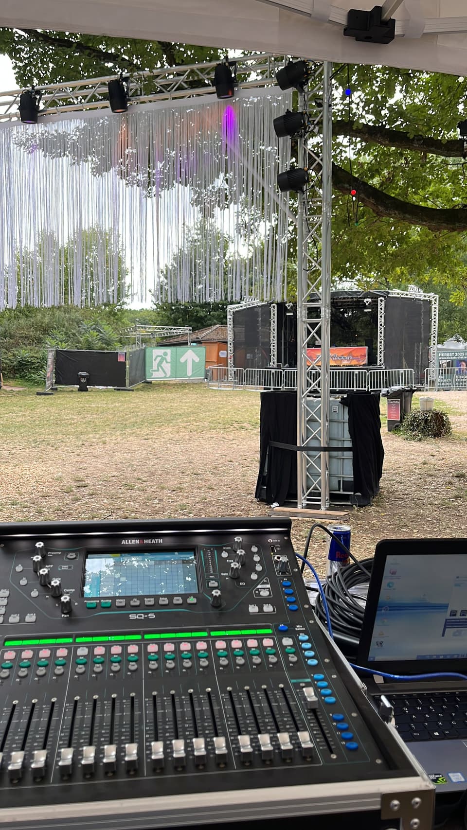 Allen-&-Heath-Mischpult vor einer Traverse mit Lautsprechern auf einem Open-Air-Gelände