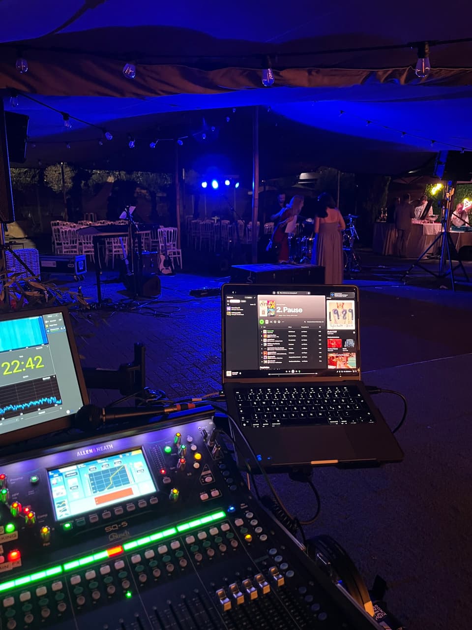 Mischplatz mit Mischpult und Laptops in einem Zelt bei einem Abendkonzert